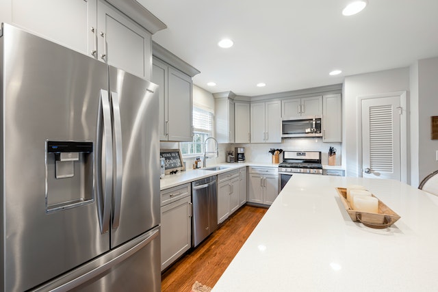 white%20kitchen%20with%20stainless%20steel%20two-door%20fridge%20and%20marble%20countertops